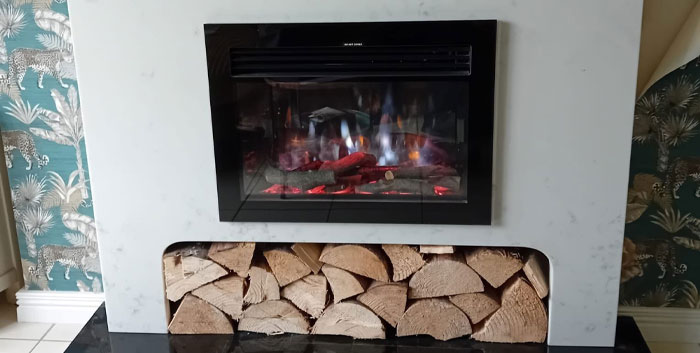 PH Fireplaces marble fireplace with glass fronted gas fire and log storage